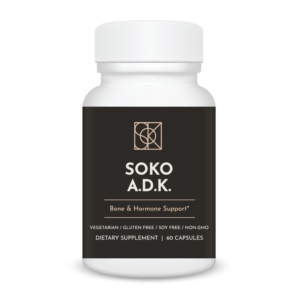 Soko A.D.K. supplement bottle on wooden table with natural light, premium vitamins A D3 and K2 MK-7 for bone density, calcium utilization, and cardiovascular support