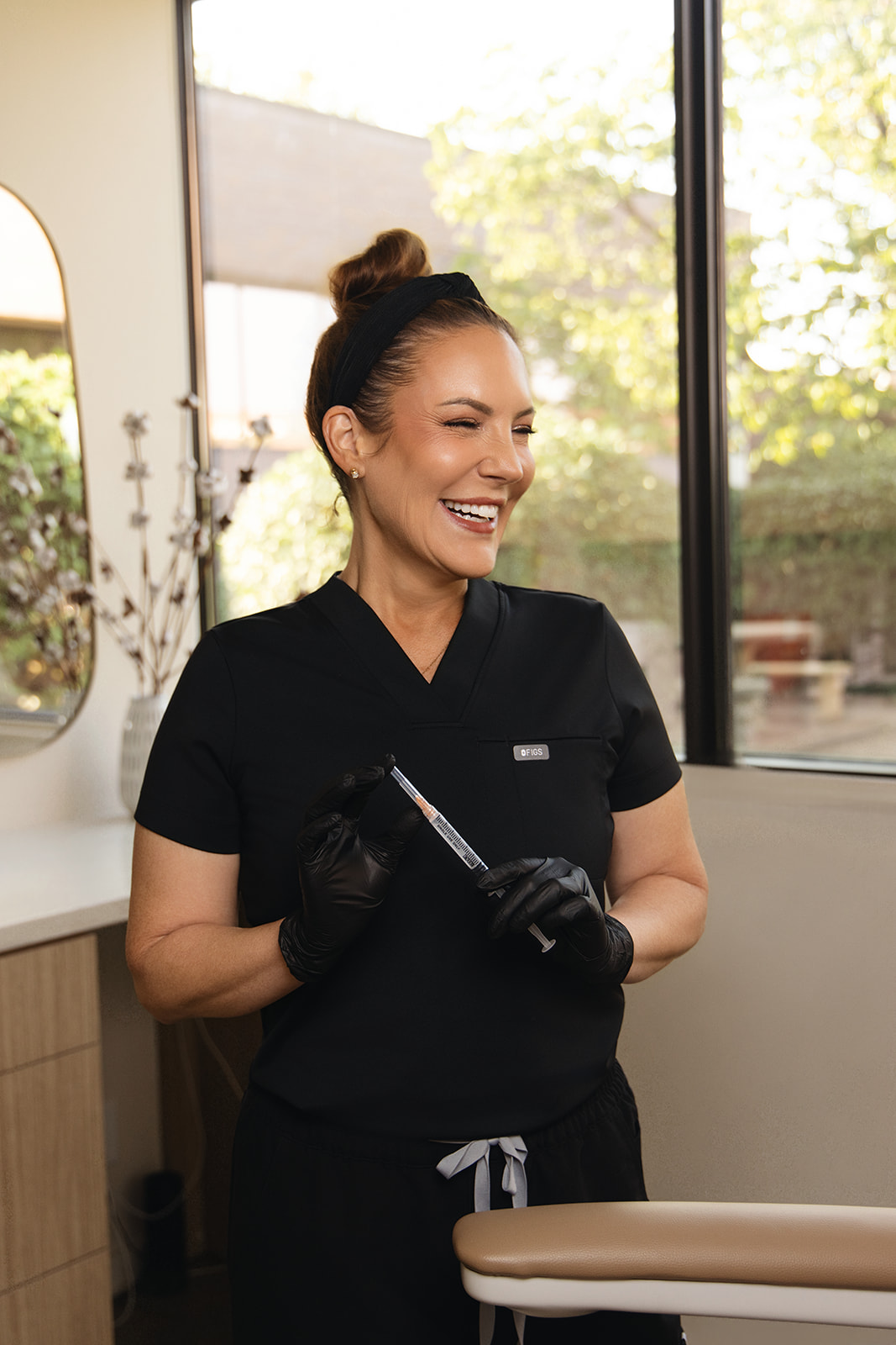 Ashley Williams, RN Leawood Nurse Injector holding a dysport injection needle.